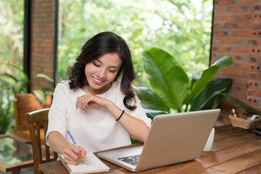 Kahve dükkanında dizüstü bilgisayar kullanırken Asyalı çekici bir yazı.. 