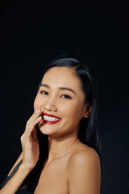 Siyah arka planda parlak ruju olan güzel bir genç kadın.