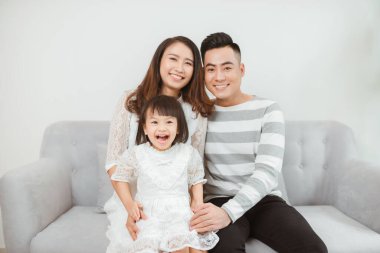 Mutlu, genç bir aile kanepede oturuyor ve birlikte iyi vakit geçiriyoruz.