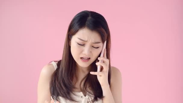 Mujer Asiática Molesta Usando Teléfono Móvil Mientras Sonríe Aislado Sobre — Vídeos de Stock