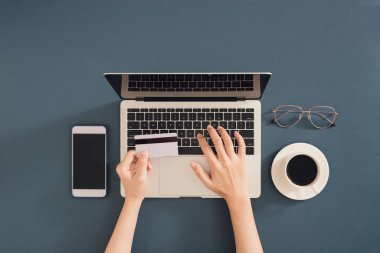 İnternet bankacılığı. Ödeme sürecini tamamlamak için kredi kartı bilgilerini bilgisayara yazan kızın yakın çekim eli