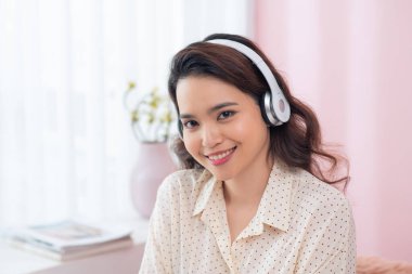 Müzik dinleyen güzel Asyalı bir kadının portresi. 