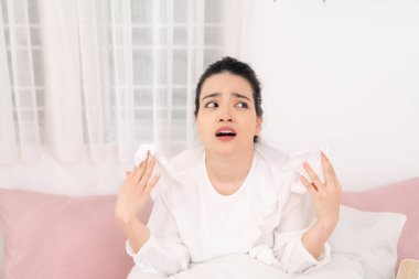 Yatağında battaniyeyle yatan hasta kadın yüksek ateş ve nezle olmuş, dinleniyor..