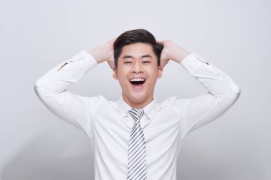 Yakışıklı, heyecanlı, mutlu, mutlu, kameraya bakan, el ele tutuşan, beyaz gömlekli, beyaz dişli, beyaz arka planda soyutlanmış genç bir adam.