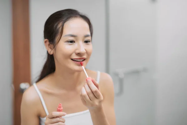 Wanita Muda Menerapkan Gloss Untuk Bibir Melihat Cermin — Stok Foto