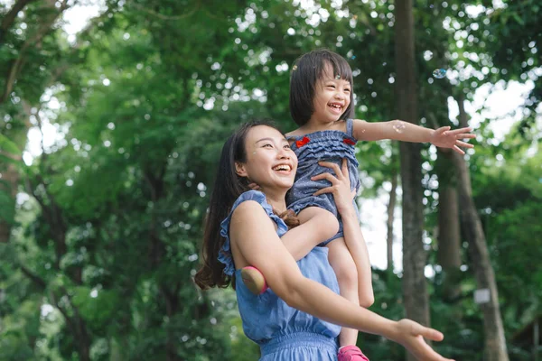 Küçük kız annesi doğası ve güneş ışığı, Aile kavramı ile sarılma portresi