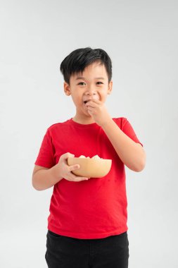 Küçük şirin çocuk gülümsüyor ve elinde bir kase şeker tutuyor.. 