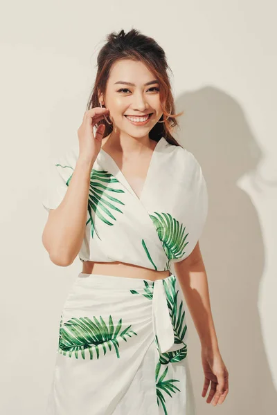 Beautiful young woman in tropical print green and white dress