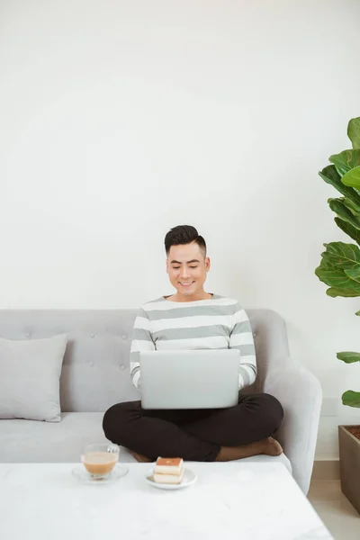 Junger Mann Benutzt Latop Wenn Auf Dem Sofa Sitzt Arbeit — Stockfoto