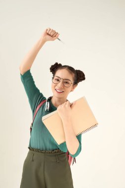 Asyalı genç bir kız öğrenci zafer kazandıktan sonra yumruğunu kaldırıyor..