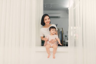 Pencerenin yanındaki eşikte oturan anne ve kızı