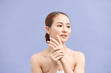 Çekici genç kadın menekşe üzerine el kremi sürüyor.