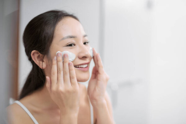 Young girl washing her face with soap.