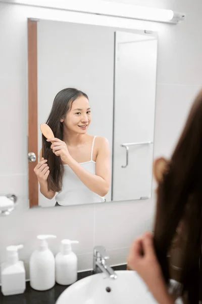 Wanita Muda Cantik Melihat Cermin Sambil Menyikat Rambut Berdiri Kamar — Stok Foto