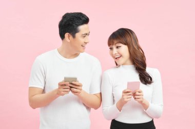 Neşeli genç çift akıllı telefonu izliyor.