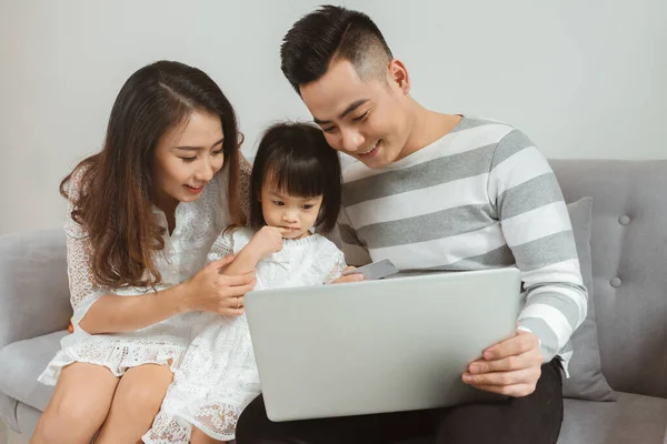 Família Jovem Usando Laptop Enquanto Senta Sofá Casa — Fotografia de Stock