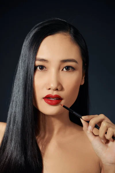 美しい若い女性の顔 化粧ブラシで唇メイクを適用する女性 — ストック写真