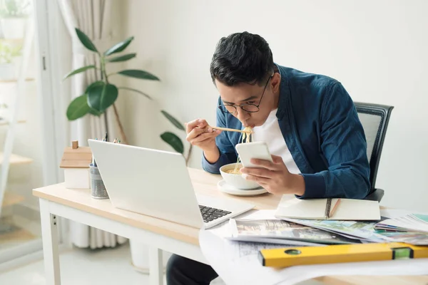 Fröhlicher Ingenieur Mit Dessert Sitzt Vor Computerbildschirm Und Isst Nudeln — Stockfoto