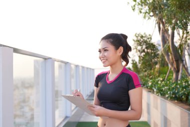 Parkta dururken panoya yazı yazan kadın çalıştırıcı. 