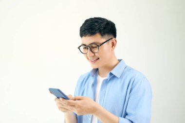 Beyaz arka planda akıllı telefonu olan çekici bir genç.