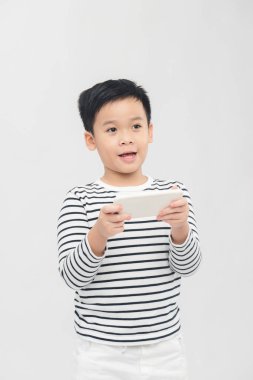 Çocuk, beyaz arkaplan üzerinde yüz ifadesi ile hareketli oyunlar oynamaktan hoşlanıyordu.