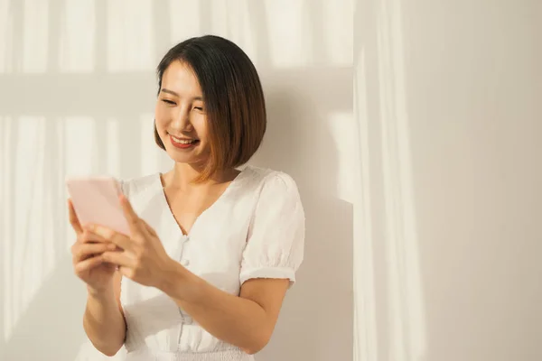 Hermosa Joven Asiática Mujer Pie Pared Blanca Relajarse Mensaje Texto —  Fotos de Stock
