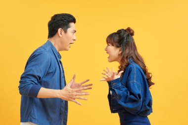 Profil kenarı portresi iki çekici sinirli agresif insanın kavga suçu olan parlak turuncu arka plan üzerinde izole edilmiş. Olumsuz duygular konsepti.