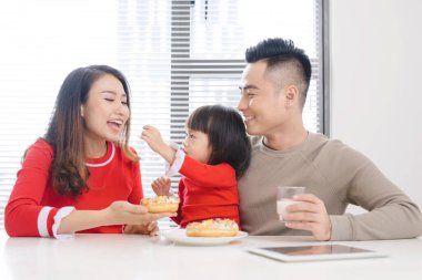 Genç Asyalı aile mutfakta kahvaltı yapıyor..