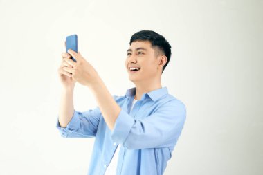 Genç adam akıllı telefonuna bakıyor.