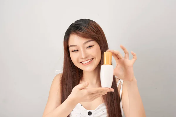 白い背景に手で白い化粧チューブプラスチックと製品を示す肖像美しいアジアの女性 — ストック写真