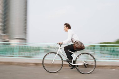 Şehir merkezinde bisiklet süren Asyalı çılgın adamın bulanık görüntüsü hız ve hippi trendli ulaşımıyla gidip geliyor.