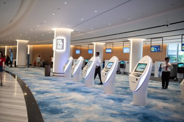 SINGAPORE - Haziran, 2019: Singapur Changi Havaalanı, Terminal 4 'teki kendini kontrol eden bir yolcu. Changi Havaalanı Singapur 'a hizmet veren büyük bir sivil havaalanıdır..