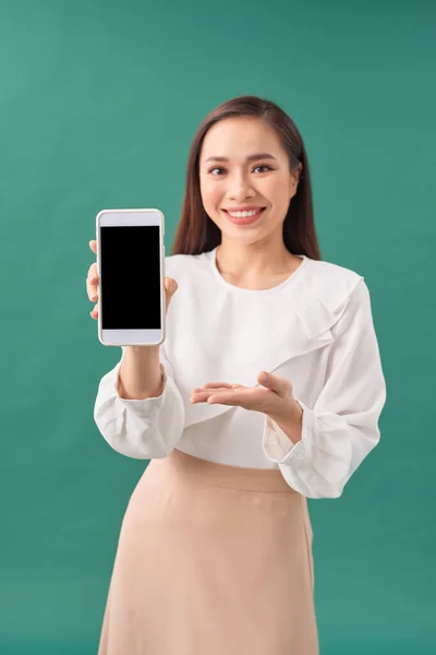 Usmívající Žena Ukazuje Smartphone Stojící Tyrkysovém Pozadí — Stock fotografie