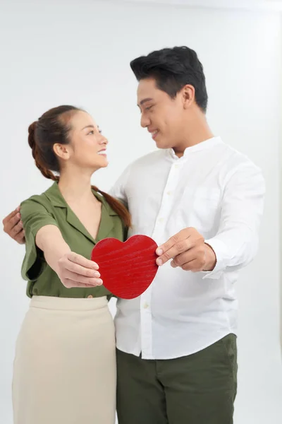 赤いハートを持つ若い愛のカップル幸せな笑顔を受け入れる白い背景に隔離されたバレンタインデーのコンセプト — ストック写真