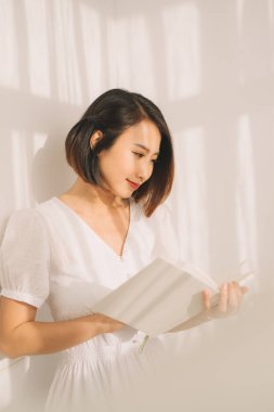 Ilık, güneşli bir günde kitap okuyan bir kadın.