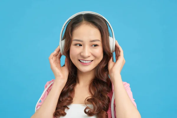 可爱的女孩 用耳机 蓝色背景听音乐 — 图库照片