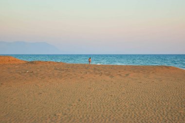 Kumsalda yürürken.
