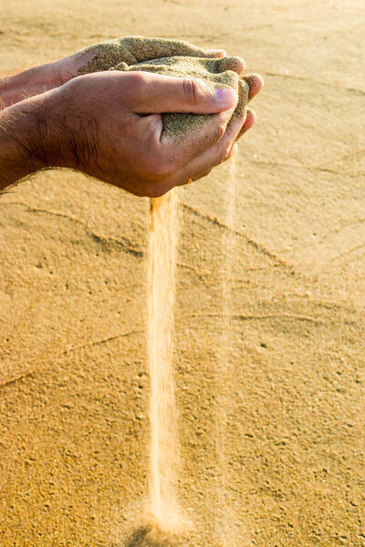 Sand through fingers.