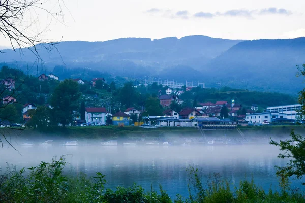 Casas e rio no nevoeiro da noite . — Fotografia de Stock