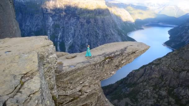 Norveç Trolltunga Uçurumun Kenarındaki Güzel Elbiseli Kız Yavaş Çekim Videosu — Stok video