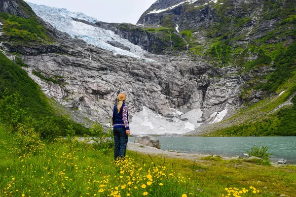 Genç kız, Boyabreen buzuluna bakıyor. Eriyen buzullar gölü berrak suyla oluşturur. Norveç. — Stok fotoğraf