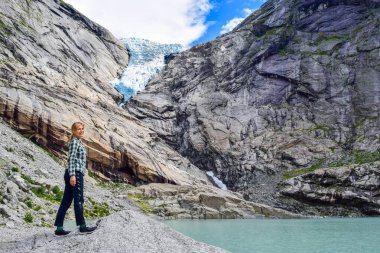 Brikdalsbreen buzulunun yanındaki genç kadın. Norveç.