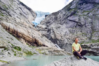 Briksdalsbreen buzulunun yanındaki adam. Norveç.