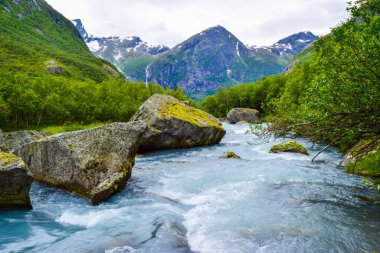 River which is located near path to the Briksdalsbreen (Briksdal) glacier. The melting of this glacier forms waterfall and river with clear water. Jostedalsbreen National Park. Norway. clipart