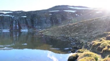 Birçok sivrisinek bir dağ gölünün üzerinde uçar. Yavaş çekim videosu. Göl, Aurlandsvegen (F243) adlı ulusal turist yolu yakınlarında yer almaktadır. Norveç.