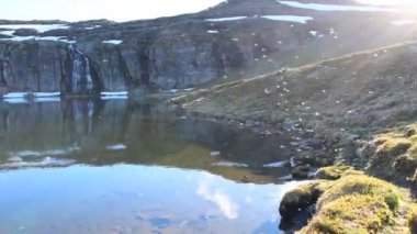 Birçok sivrisinek bir dağ gölünün üzerinde uçar. Göl, Aurlandsvegen (F243) adlı ulusal turist yolu yakınlarında yer almaktadır. Norveç.