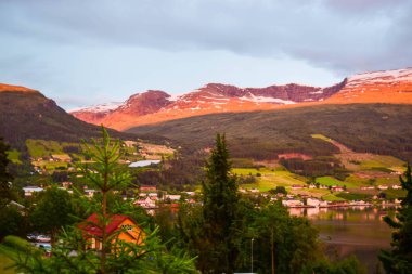 Batan güneşin son ışınları. Güzel Innvikfjord ve Innvik köyünden dağların manzarası. Innvikfjord, Sogn og Fjordane 'nin Stryn belediyesinde Nordfjord' un bir alt fiyordudur. Norveç.