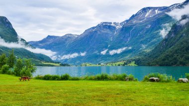 Jostedalsbreen Ulusal Parkı 'nın buzullarının bulunduğu güzel Oldevatnet buzul gölü ve sisli dağların manzarası. Norveç.