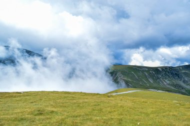 Transalpina Yılan Yolu DN67C üzerinde sis ve alçak bulutlar. Burası Romanya 'nın en güzel dağlık rotalarından biri ve Romanya ve Karpatlar' ın en yüksek asfalt yolu..