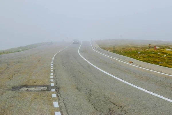Cars in fog on the Transalpina road DN67C. This is one of the most beautiful alpine routes in Romania and the highest mountain asphalt road in Romania and  Carpathians mountains.